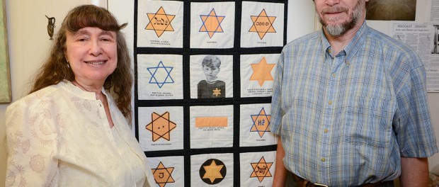 Beverly and Lawrence Newman pose in front of a quilt made by Susan Kohnstam that is made up of the different yellow stars Jewish people were forced to wear during the Holocaust. The little boy in the center in Susan's husband, Pieter, who survived the Holocaust and had Anne Frank as a babysitter. The Newmans run a small nonprofit named in honor of Beverly's father, The Al Katz Center for Holocaust Survivors & Jewish Learning Inc. The central mission is helping elders and their families fight guardianship proceedings. (September 24, 2014) (Herald-Tribune staff photo by Rachel S. O'Hara)
