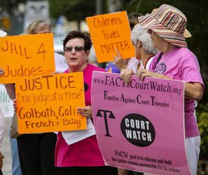 Sheila Jaffe (left) and Natalie Andre (right), President of FACTS (Families Against Court Travesties), protest with a group of people about the state of guardianship outside the South County Courthouse in Delray Beach February 24, 2016. (Lannis Waters / The Palm Beach Post)